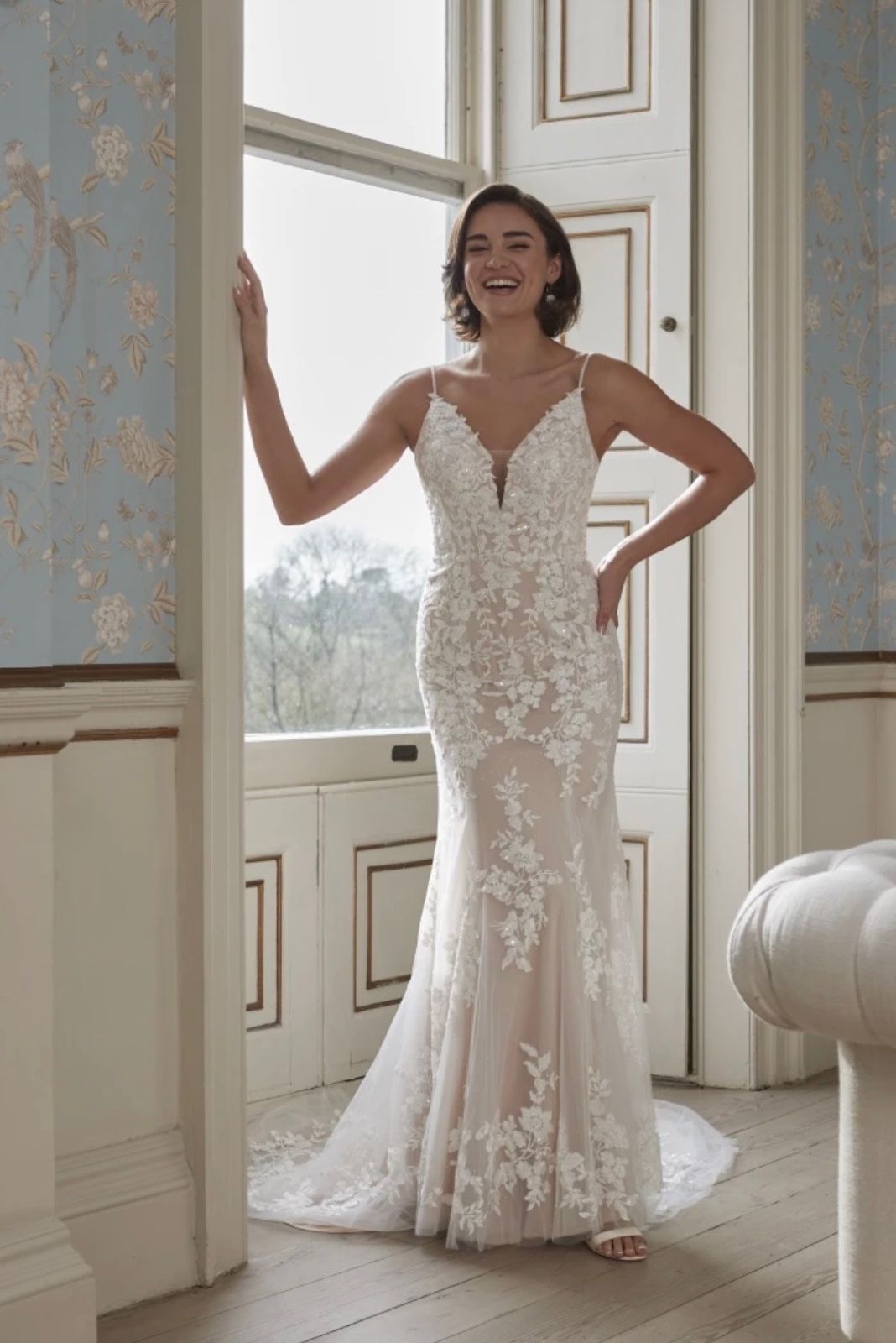 A fitted lace mermaid gown with a plunging neckline and delicate straps